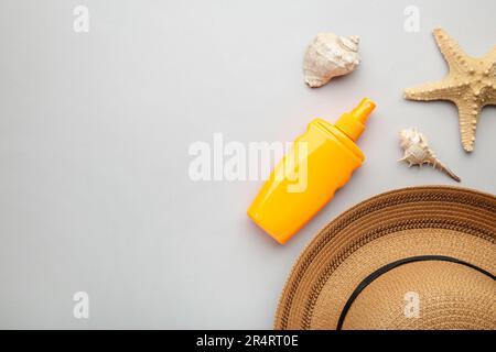 Sunscreen bottle with other accessories on grey background. Cosmetics for safe sunburn. Sun protection cream Stock Photo