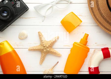 Sunscreen bottle with hat, glasses and other accessories on white background. Cosmetics for safe sunburn. Sun protection cream Stock Photo