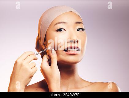 Woman, bandage and plastic surgery with injection on face in studio background for asian beauty. Model, skincare filler and collagen with cosmetic Stock Photo