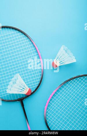 Shuttlecocks and badminton rackets on blue background. Top view. Stock Photo