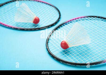 Shuttlecocks and badminton rackets on blue background. Top view. Stock Photo