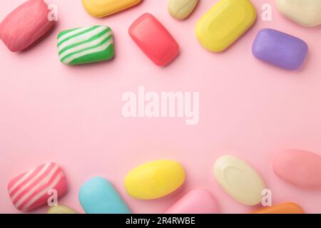 Different soaps in different soap dishes. A lot of solid soap for hygiene and cleanliness. Colorful soap and remnants are scattered on pink background Stock Photo