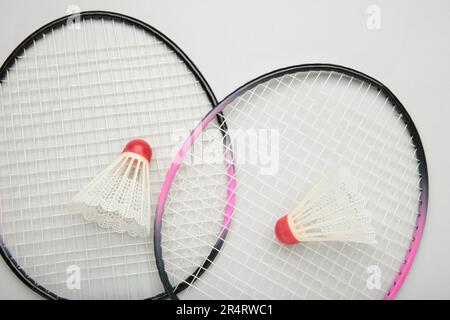 Shuttlecocks and badminton rackets on grey background. Top view. Stock Photo