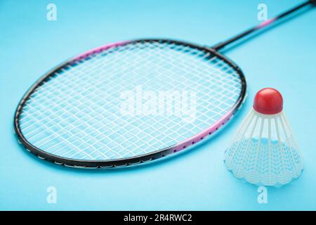 Shuttlecocks and badminton racket on blue background. Top view. Stock Photo