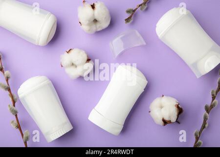 White deodorants with willow twigs on purple background. Top view. Stock Photo