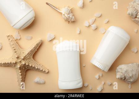 Deodorants for women and seashells on beige background. Top view Stock Photo