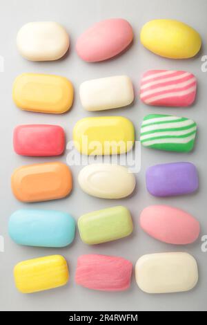 Different soaps in different soap dishes. A lot of solid soap for hygiene and cleanliness. Colorful soap and remnants are scattered on grey background Stock Photo