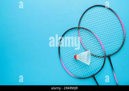 Shuttlecocks and badminton racket on blue background. Top view. Stock Photo