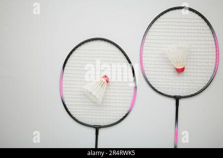 Shuttlecocks and badminton rackets on grey background. Top view. Stock Photo