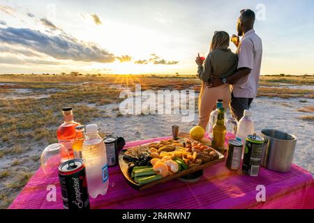 Couple enjoying sundowner lifestyle in Onguma Game Reserve, Namibia, Africa Stock Photo