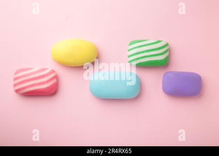 Different soaps in different soap dishes. A lot of solid soap for hygiene and cleanliness. Colorful soap and remnants are scattered on purple table. Stock Photo