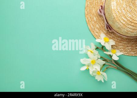 Straw hat with spring flowers on mint background. Top view Stock Photo