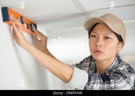 female asian builder using spirit level Stock Photo