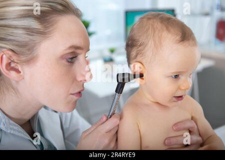 the doctor examines the childs ear Stock Photo