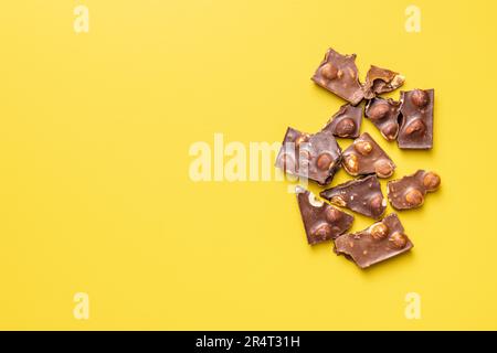 Chocolate bars with nuts on the yellow background. Top view. Stock Photo