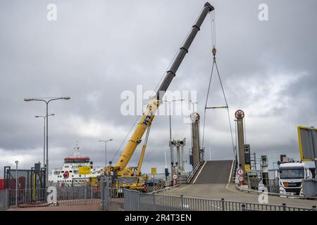 HOLWERT - A crane operates the car bridge so that cars can drive on and off the boat again. The ferry service between the mainland and Ameland has resumed after problems with the car bridge in the harbor of Holwert prevented travelers from disembarking with a car, so they were taken back to Ameland. ANP JILMER POSTMA netherlands out - belgium out Stock Photo