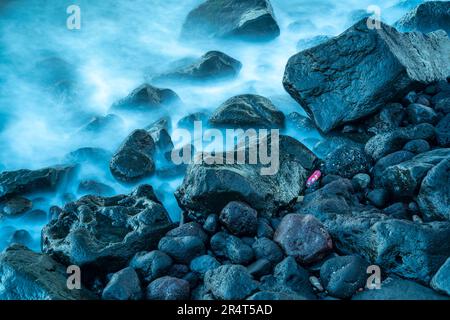 View of discareded plastic bottle and waves over stones on beach in Giardini Naxos, Sicily, Mediterranean, Italy, Europe Stock Photo
