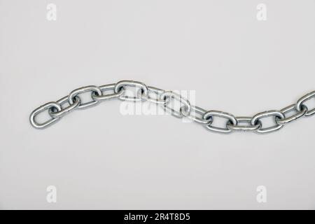 Top view of piece of strong silver metal chain placed on gray background Stock Photo
