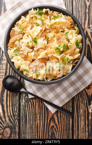 Krautfleckerl are a traditional Austrian food made out of noodles fleckerl pasta and caramelized cabbage closeup on the bowl on the table. Vertical to Stock Photo