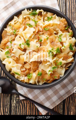 Krautfleckerl Austrian Noodles with Cabbage closeup on the bowl on the table. Vertical top view from above Stock Photo
