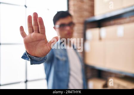 Down syndrome man ecommerce business worker doing stop sign with hand at office Stock Photo