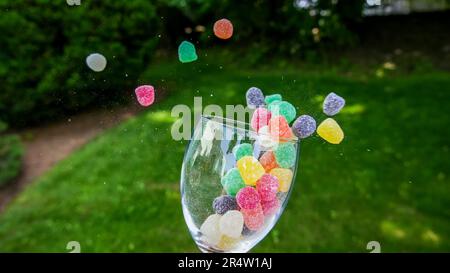 Colorful candy flying out from inside glass outdoor Stock Photo