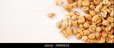 Spicy flavored peanut kernel spilling on white table background. Stock Photo
