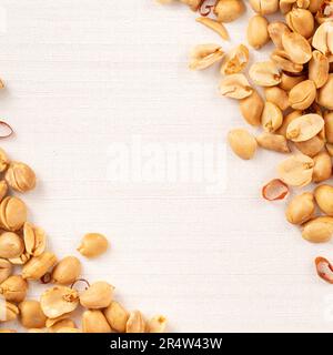Spicy flavored peanut kernel spilling on white table background. Stock Photo