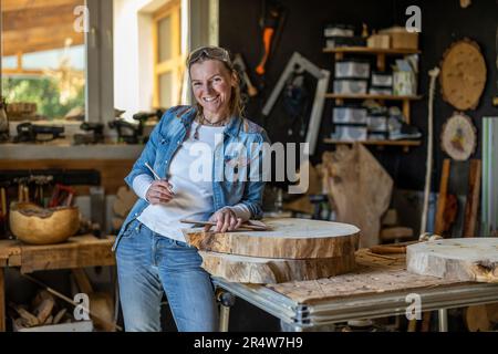 Portrait of confident craftswoman in her workshop Stock Photo