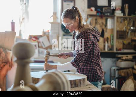 Craftswoman working with wood in carpentry workshop Stock Photo