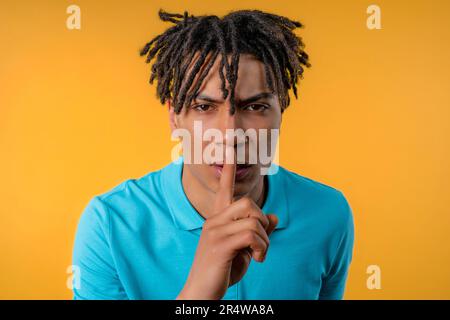 Handsome african man with gesture of shhh, secret, silence, conspiracy, gossip Stock Photo