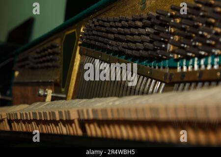 A close-up of the internal parts of a piano or grand piano. Selective focus. Details of the musical instrument from the inside. Hammers and strings in Stock Photo