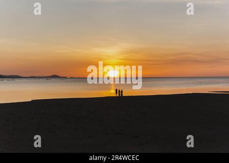 Silhouette of blurred people taking picture of sunset on the beach. Stock Photo
