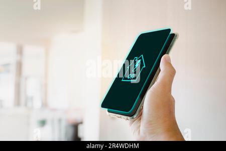 Home electrical system active icon on smartphone screen holding in a hand. Home electrical technology concept. Stock Photo