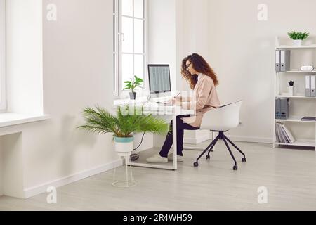 Woman analyst working with spreadsheet business data in office Stock Photo