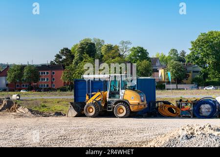 Construction site with a yellow wheeled bulldozer standing on it and folded cables. Stock Photo