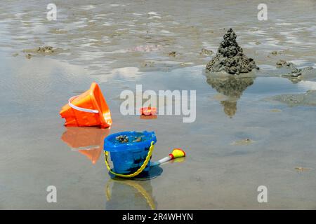 Sunny day on the beach on Hilton Head Island, South Carolina.  Buckets and a sand castle have been abandoned in a puddle. Stock Photo