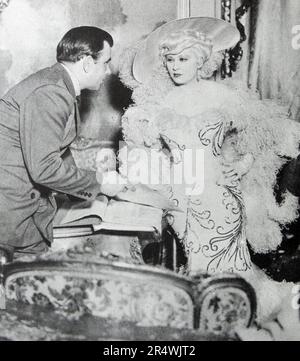 Mae West and production assistant Boris Petroff discuss 'shooting script'.I'm No Angel (1933) is Mae West's third motion picture. Stock Photo