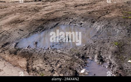 Dirty country road with large puddles after rain. Dirt road after heavy rains. Beginning of autumn. Off-road, 4x4. muddy road Stock Photo