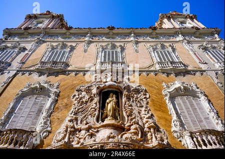 Valencia, Spain - July 15, 2022:  Low angle view of the facade with sculpture, window, and balcony. Exterior architecture of the Palace of the Marques Stock Photo