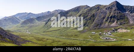 Independence Mine State Historical Park Visitor Center surrounded by the Talkeetna Mountains across Hatcher Pass under a sunny, blue sky Stock Photo