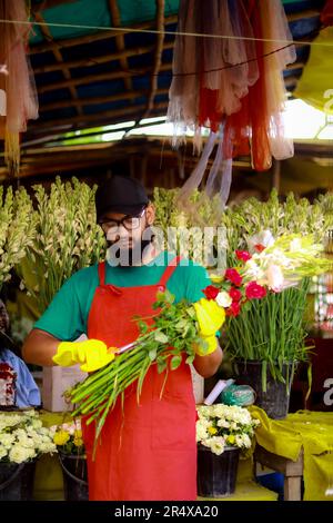 Florists man working with flowers at a greenhouse. Happy mature man feeling proud of her flowers while working in plant nursery, Florist entrepreneur Stock Photo