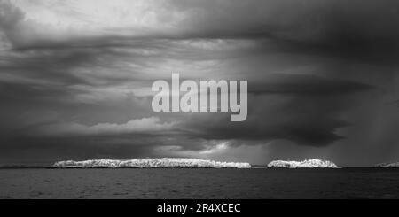 Dramatic cloud formation over rocks in Lake Superior in infrared; Thunder Bay, Ontario, Canada Stock Photo