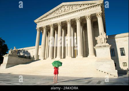 Woman with umbrella in vibrant color views the U.S. Supreme Court in Washington, DC, USA; Washington, District of Columbia, United States of America Stock Photo