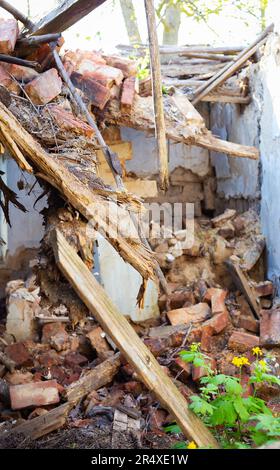 Old abandoned one-story house in disrepair. Collapsed walls Stock Photo