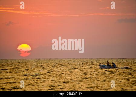 Fishing boat at sunset; Turneffe Island, Belize Stock Photo