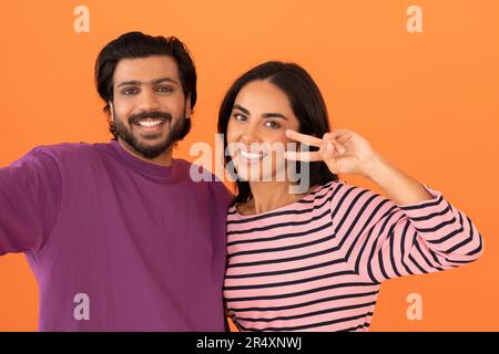 Studio portrait of cheerful indian couple taking selfie together Stock Photo