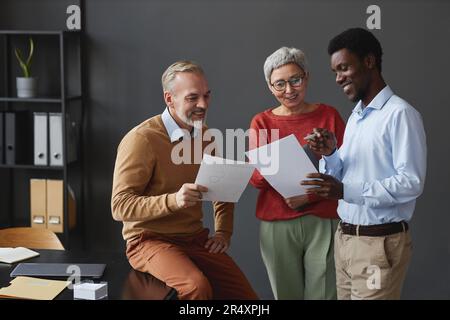 Diverse group of business people with senior workers collaborating on project in office Stock Photo