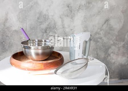 cheerful girl using a smooother while baking cake in the kitchen Stock Photo