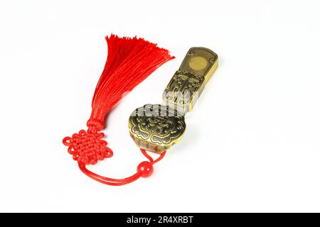 Traditional chinese brass amulet as presents. Chinese style amulet with red decorative good luck knots means good fortune, happiness and rich on white Stock Photo